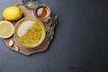 Bowl of lemon sauce and ingredients on dark table, top view with space for text. Delicious salad dressing Royalty Free Stock Photo