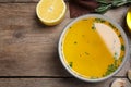 Bowl of lemon sauce and ingredients on wooden table, flat lay with space for text. Delicious salad dressing Royalty Free Stock Photo