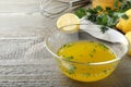 Bowl with lemon sauce and ingredients on wooden table, space for text. Delicious salad dressing Royalty Free Stock Photo
