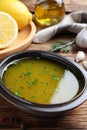 Bowl with lemon sauce on wooden table, closeup. Delicious salad dressing Royalty Free Stock Photo