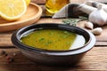 Bowl with lemon sauce on wooden table, closeup. Delicious salad dressing Royalty Free Stock Photo