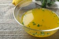 Bowl with lemon sauce on wooden table, closeup. Delicious salad dressing Royalty Free Stock Photo