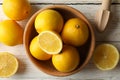 Bowl, lemons and wood juicer on background, top view Royalty Free Stock Photo