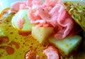 a bowl of lontong sayur. Minang specialty dish served with curry sauce with rice, eggs, crackers, bakwan, jackfruit and beans