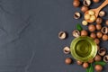 Bowl of macadamia nut oil and macadamia nuts on black stone Royalty Free Stock Photo