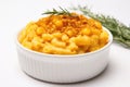 A bowl of macaroni and cheese with a sprig of rosemary