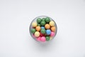 Bowl with many bright gumballs on white background, top view Royalty Free Stock Photo