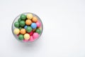 Bowl with many bright gumballs on white background, top view. Space for text Royalty Free Stock Photo