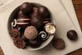 Bowl with many different delicious chocolate truffles on wooden table, top view Royalty Free Stock Photo