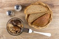 Bowl with marinated lactarius, bread in wicker basket, salt, pep