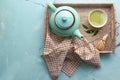 Bowl with matcha beverage, teapot and whisk on wicker tray