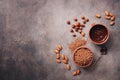A bowl of melted chocolate, cocoa powder, almonds and hazelnuts on a dark rustic background. Top view, flat lay, copy space Royalty Free Stock Photo