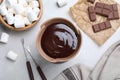 Bowl with melted chocolate and marshmallows on light grey marble table, flat lay Royalty Free Stock Photo