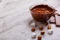 Bowl of melted milk chocolate with hazelnuts on the table Royalty Free Stock Photo