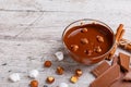 Bowl of melted milk chocolate with hazelnuts on a table next to marshmallow slices close-up Royalty Free Stock Photo