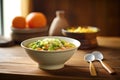 bowl of minestrone with spoon on wooden table