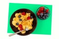 A bowl with mini pancake cereal. Tiny cereal pancakes with blueberries and raspberries Royalty Free Stock Photo