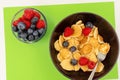 A bowl with mini pancake cereal. Tiny cereal pancakes with blueberries and raspberries Royalty Free Stock Photo