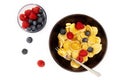 A bowl with mini pancake cereal.  Tiny cereal pancakes with blueberries and raspberries Royalty Free Stock Photo