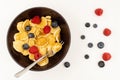 A bowl with mini pancake cereal. Tiny cereal pancakes with blueberries and raspberries Royalty Free Stock Photo