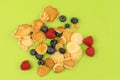 Mini pancake cereal. Tiny cereal pancakes with blueberries and raspberries Royalty Free Stock Photo