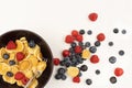 A bowl with mini pancake cereal. Tiny cereal pancakes with blueberries and raspberries. Copy space Royalty Free Stock Photo