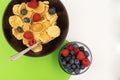 A bowl with mini pancake cereal. Tiny cereal pancakes with blueberries and raspberries. Copy space Royalty Free Stock Photo