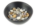 A bowl of mixed beach pebbles in soft light