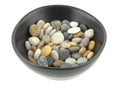 A bowl of mixed beach pebbles in soft light