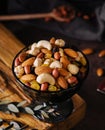 Bowl with mixed organic nuts on wooden board Royalty Free Stock Photo