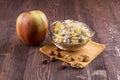 Bowl of muesli, apple, nuts, flakes, candied for a nutritious b