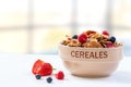 A bowl of muesli breakfast cereal and milk with berries on a rustic kitchen background Royalty Free Stock Photo