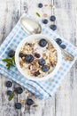 Bowl of muesli with fresh blueberries on white wooden table