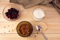 Bowl with muesli, frozen berries and glass of milk on wooden background Royalty Free Stock Photo