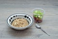 A bowl of muesli with pieces of apple and grapes