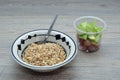 A bowl of muesli with pieces of apple and grapes