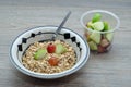 A bowl of muesli with pieces of apple and grapes