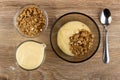 Bowl with muesli, yogurt, jug of yogurt, bowl with granola, spoon on table. Top view Royalty Free Stock Photo