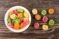 Bowl of multicolor dried pineapple and scattered on table