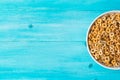 Bowl with multigrain cereals on blue wooden background, close-up, top view Royalty Free Stock Photo