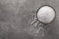 Bowl of natural sea salt on grey table, top view. Space for text Royalty Free Stock Photo