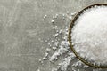 Bowl of natural sea salt on grey table, top view. Space for text Royalty Free Stock Photo