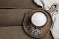 Bowl of natural sea salt on wooden table, top view. Space for text Royalty Free Stock Photo