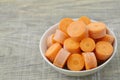 Bowl with new cut carrots thick on wooden background Royalty Free Stock Photo