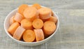 Bowl with new cut carrots thick on wooden table Royalty Free Stock Photo