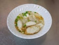 A bowl of noodle with variety of fish balls in Thai style on sta