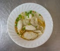 A bowl of noodle with variety of fish balls in Thai style on sta