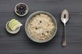 A bowl of nutritious blueberry and apple porridge and a small bowl of  apple and blueberries, with a spoon, on a dark wooden Royalty Free Stock Photo