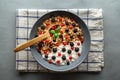 Bowl with oat granola, yogurt and black raspberries, black and red currants on a gray concrete background. Royalty Free Stock Photo