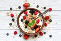 Bowl of oat granola with yogurt, fresh raspberries, blueberries, strawberries, blackberries and nuts with spoon Royalty Free Stock Photo